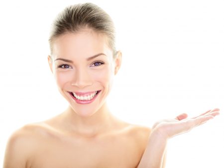 Body skincare care beauty Asian woman showing product on side with open hand. Healthy glowing skin on multi-ethnic Chinese / Caucasian girl presenting and displaying isolated on white background.